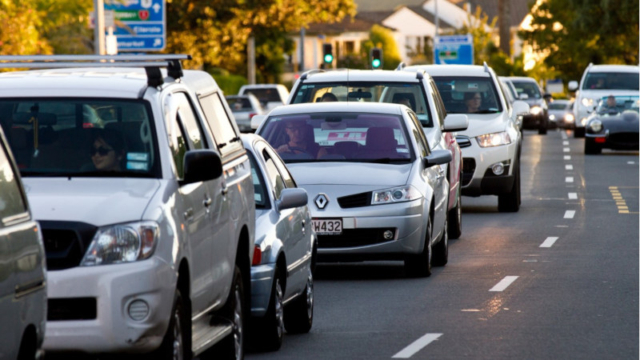 Vehicles queuing on a suburban street.